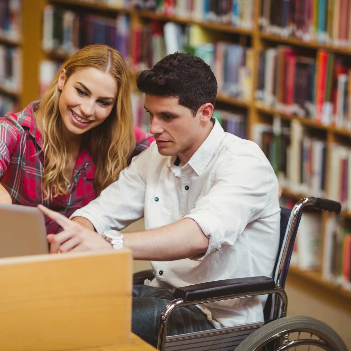 Two students studying together in a library.